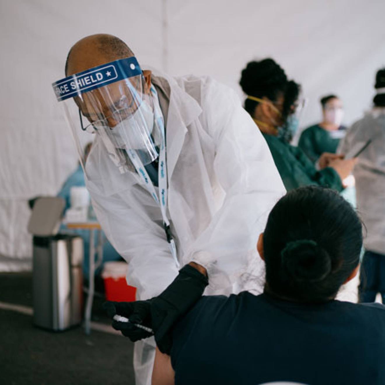 President Drake administers a vaccine to a woman at the community hub