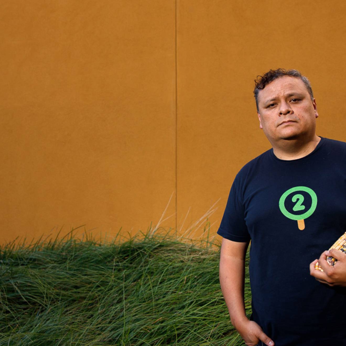 Edwin Solares outside at UC Davis holding the corn he studies