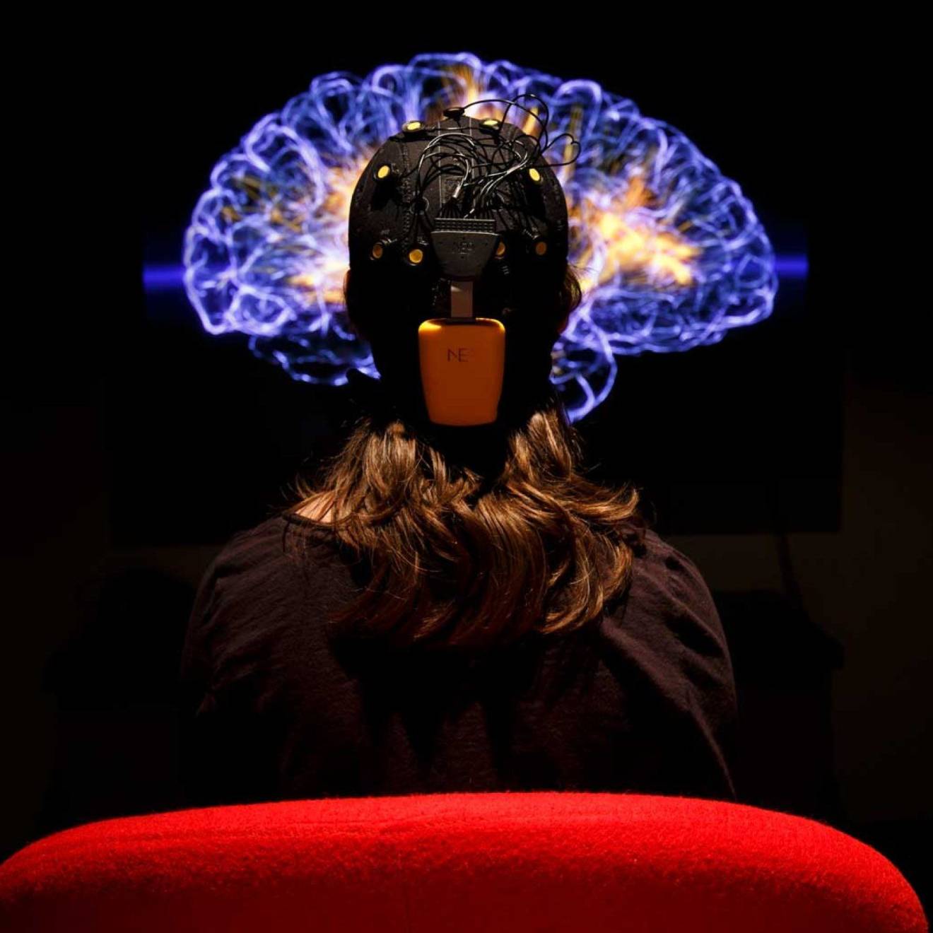 A person hooked up for an EKG looking at an image of the brain