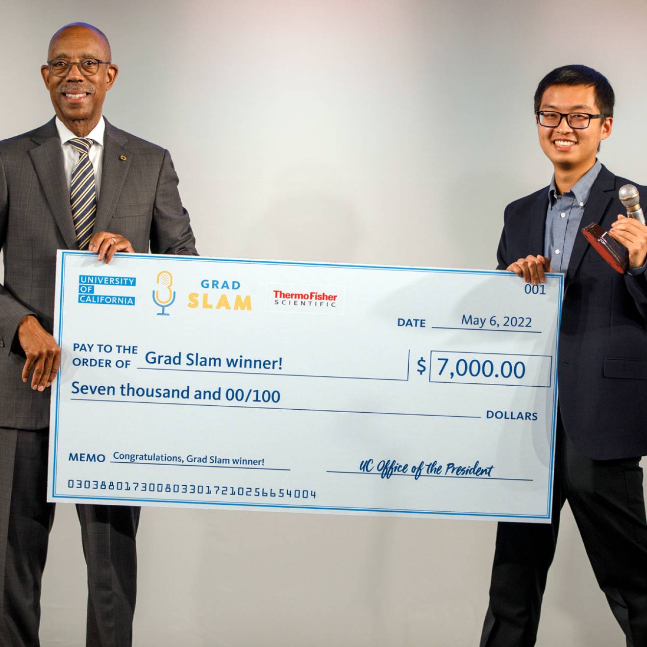 Justin Lee holds up his Grad Slam victory check with President Drake