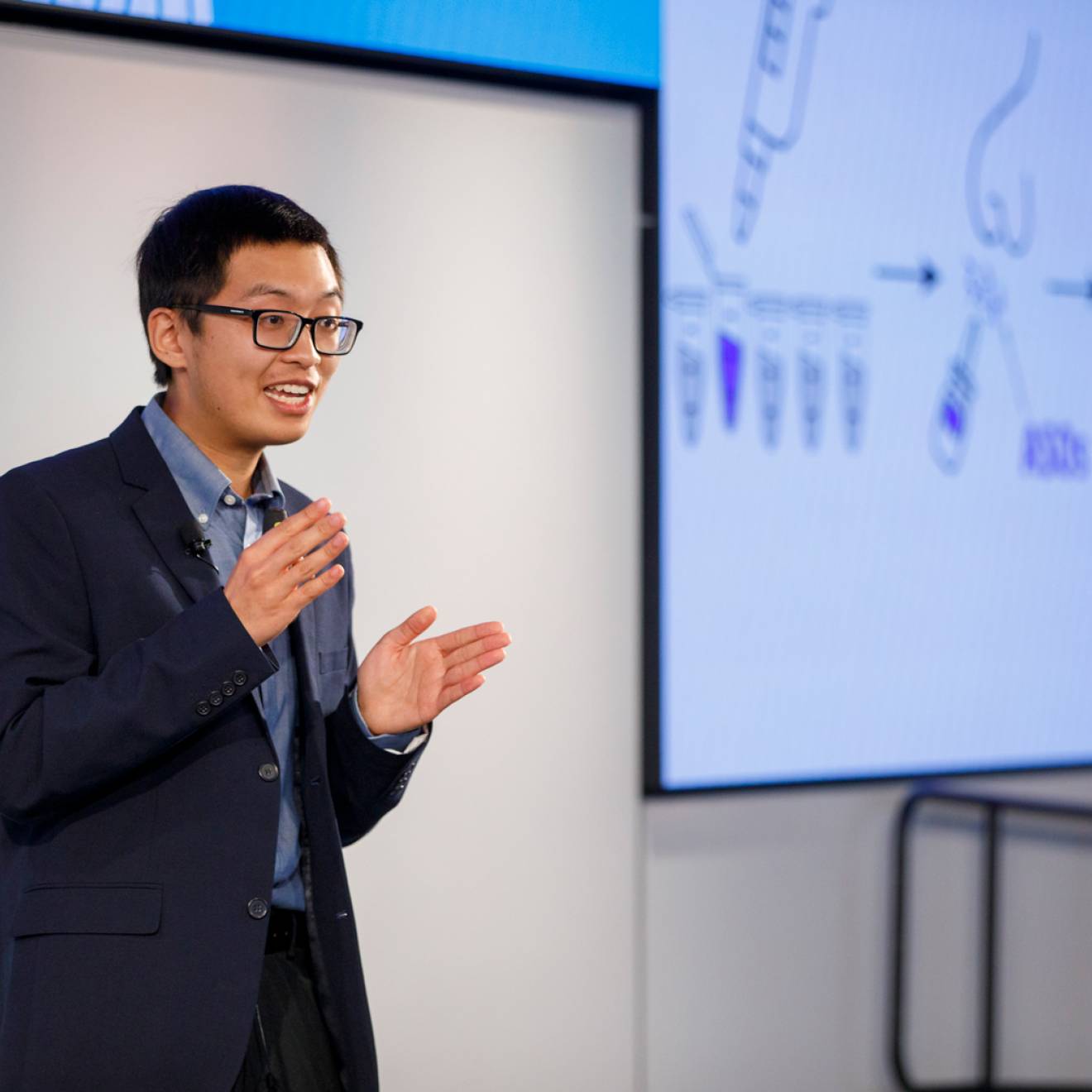 Justin Lee delivers his Grad Slam talk with a projected screen behind him