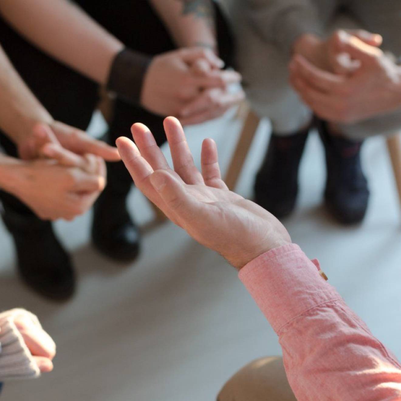 photo of hands from a group of people in discussion