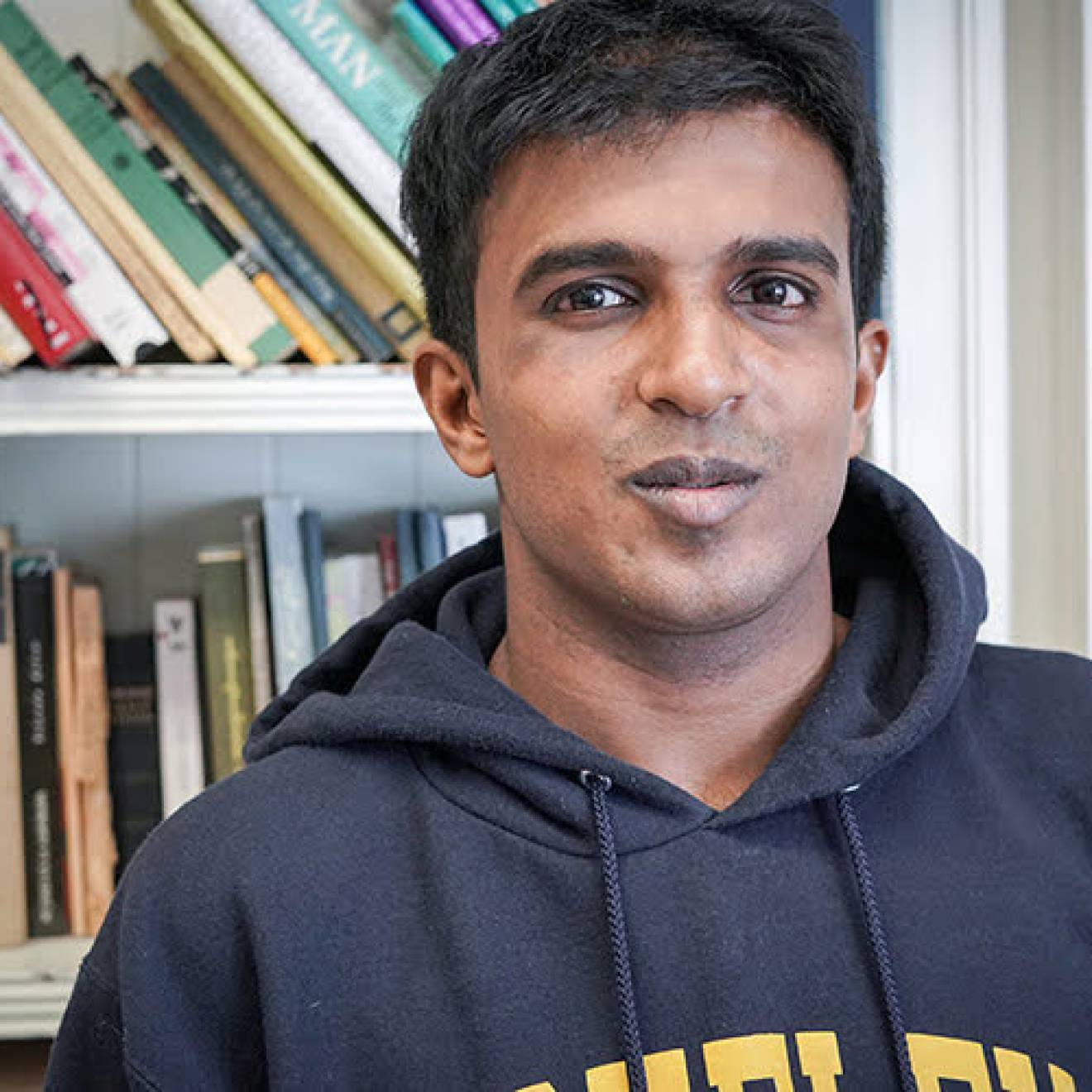 Hari Srinivasan in front of a bookcase