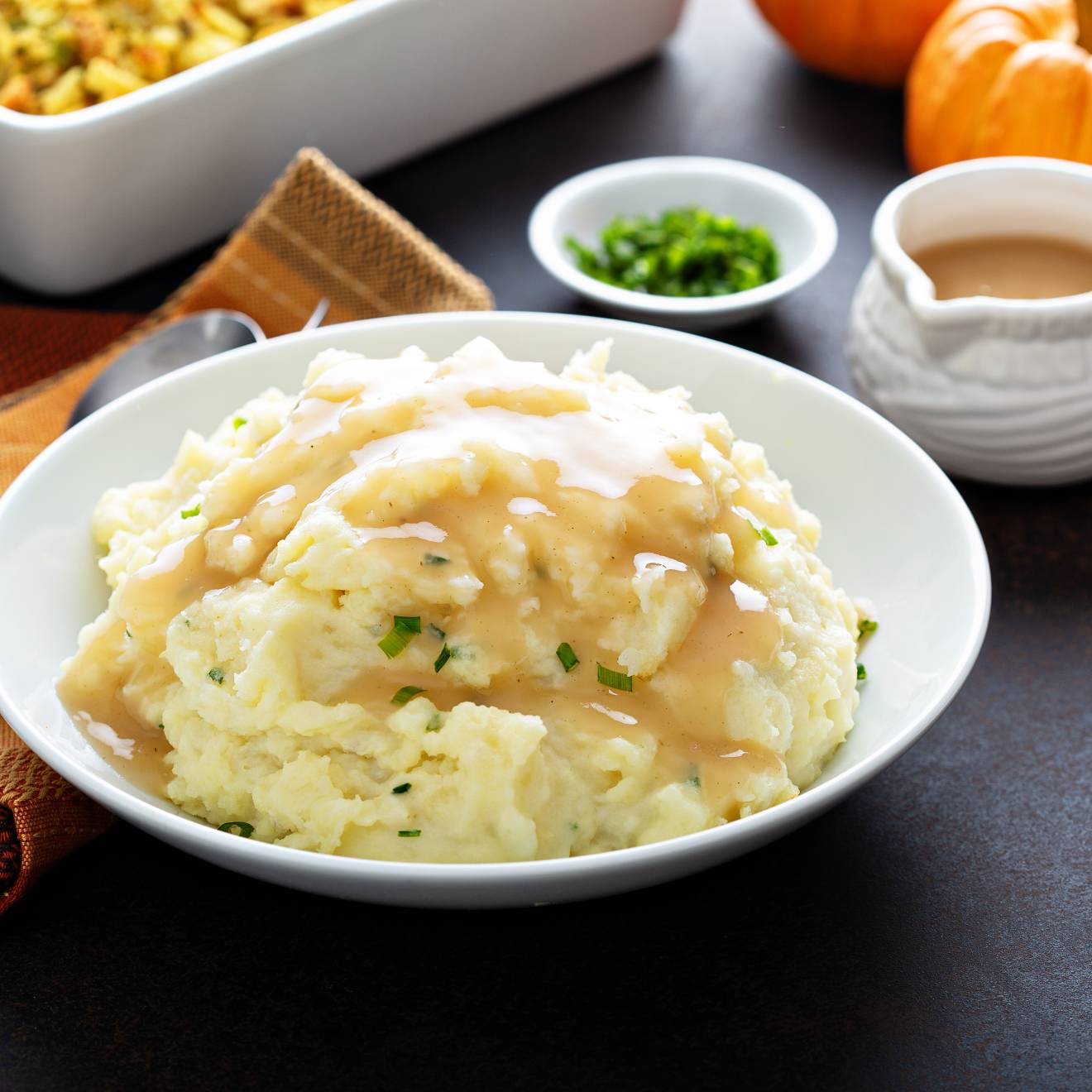 mashed potatoes, gravy and other Thanksgiving dishes on a table