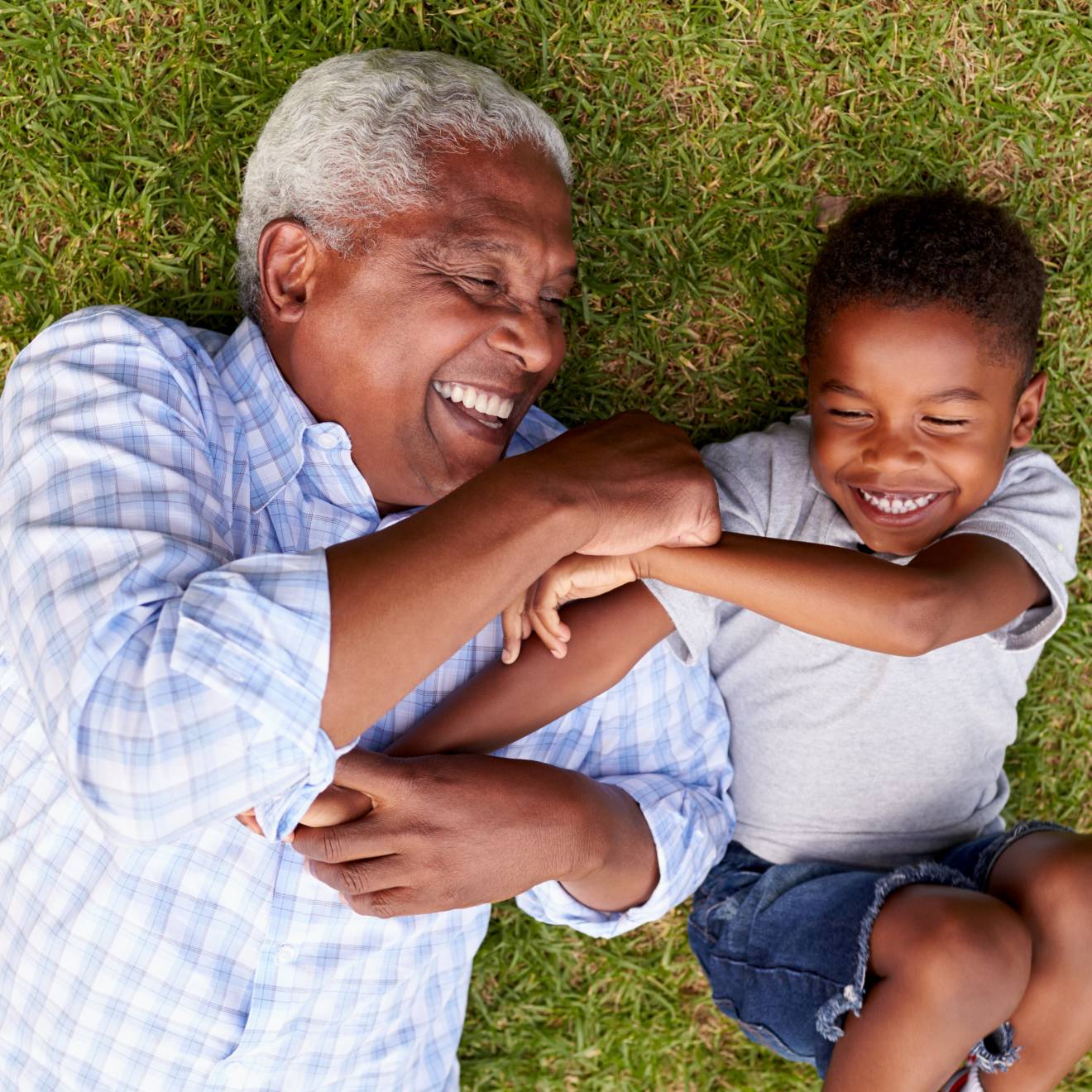 Aerial view of grandfather and grandson playing together on grass