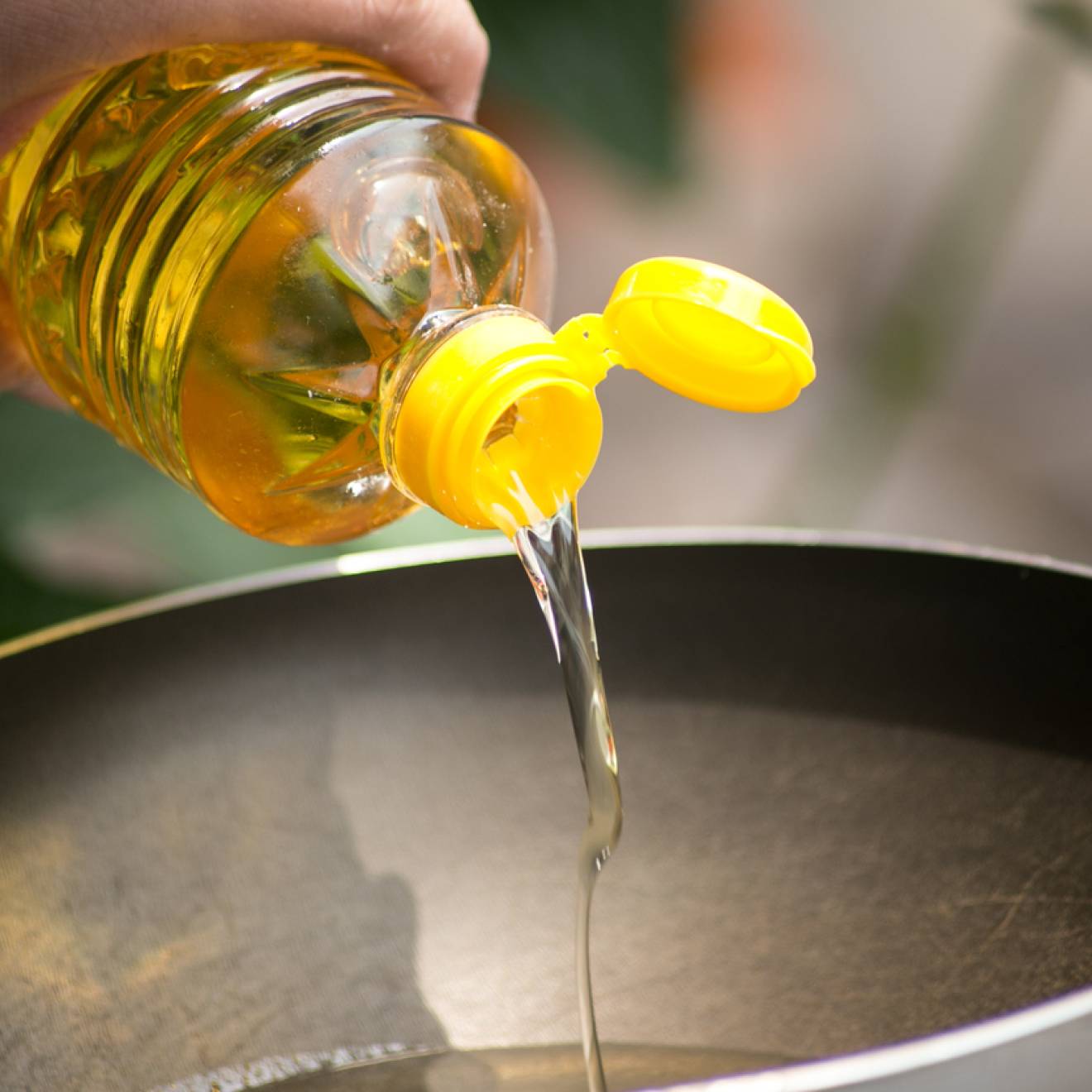 Soybean oil being poured into a hot skillet