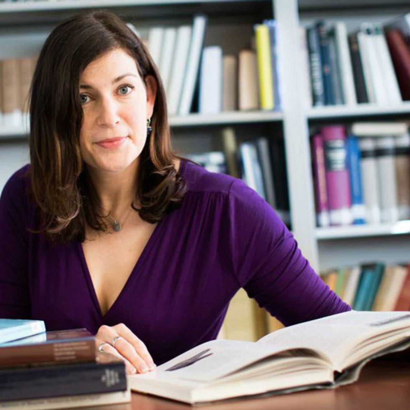 Kara Cooney at a desk with an open book