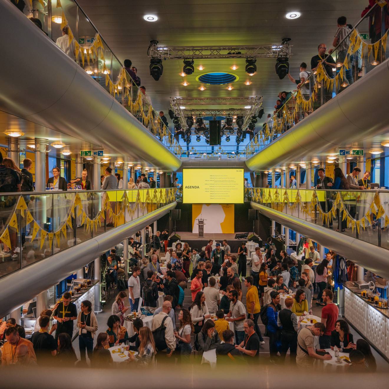 A bustling and vibrant modern hall inside a boat with several levels