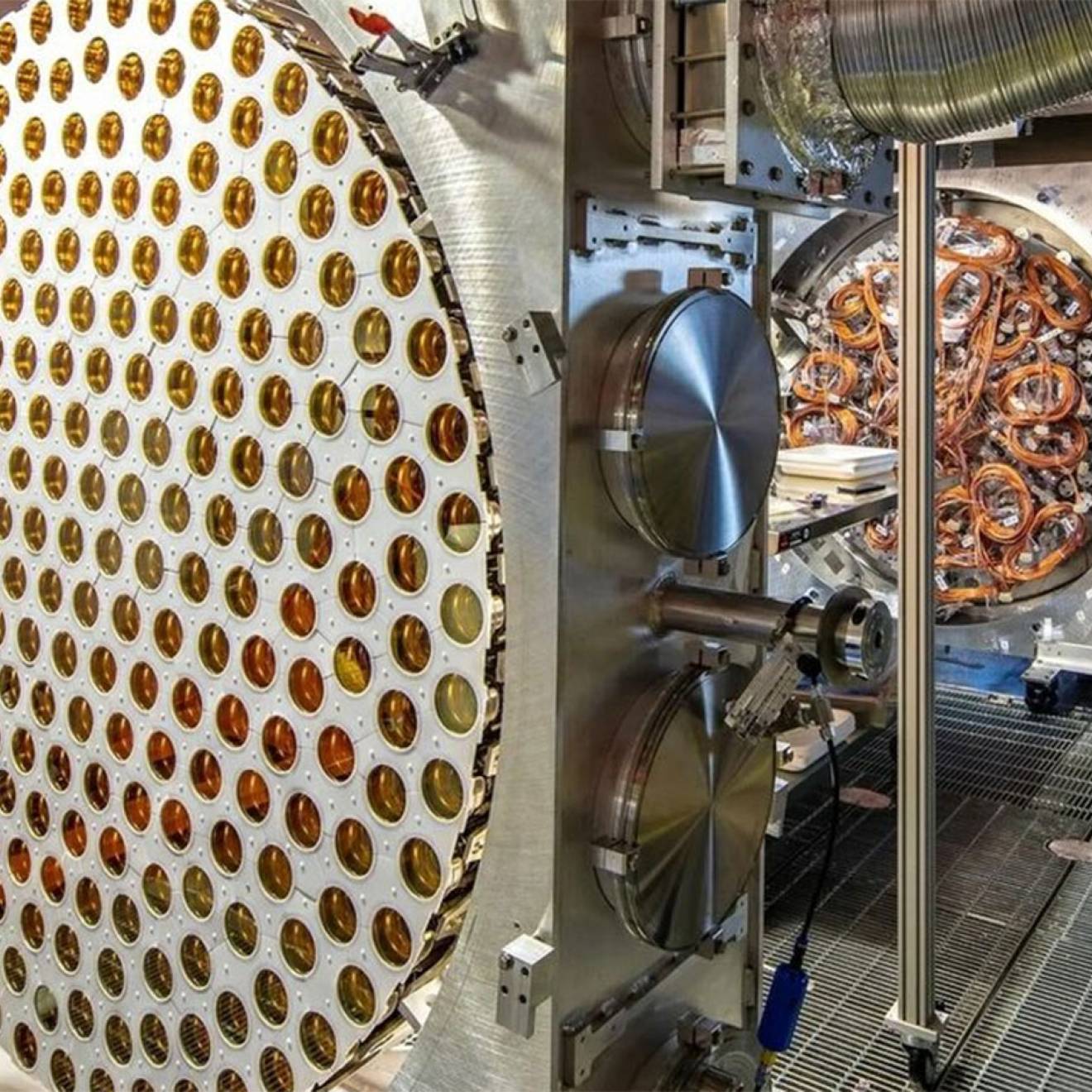 The LUX-ZEPLIN dark matter detector’s instrumentation, including a circular array of gold-toned sensors and wiring inside a clean room.