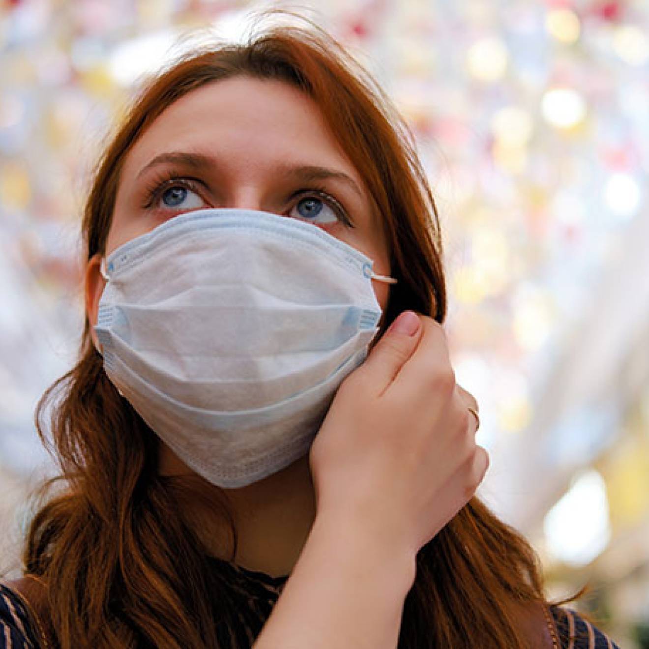 Woman thinking about taking off mask