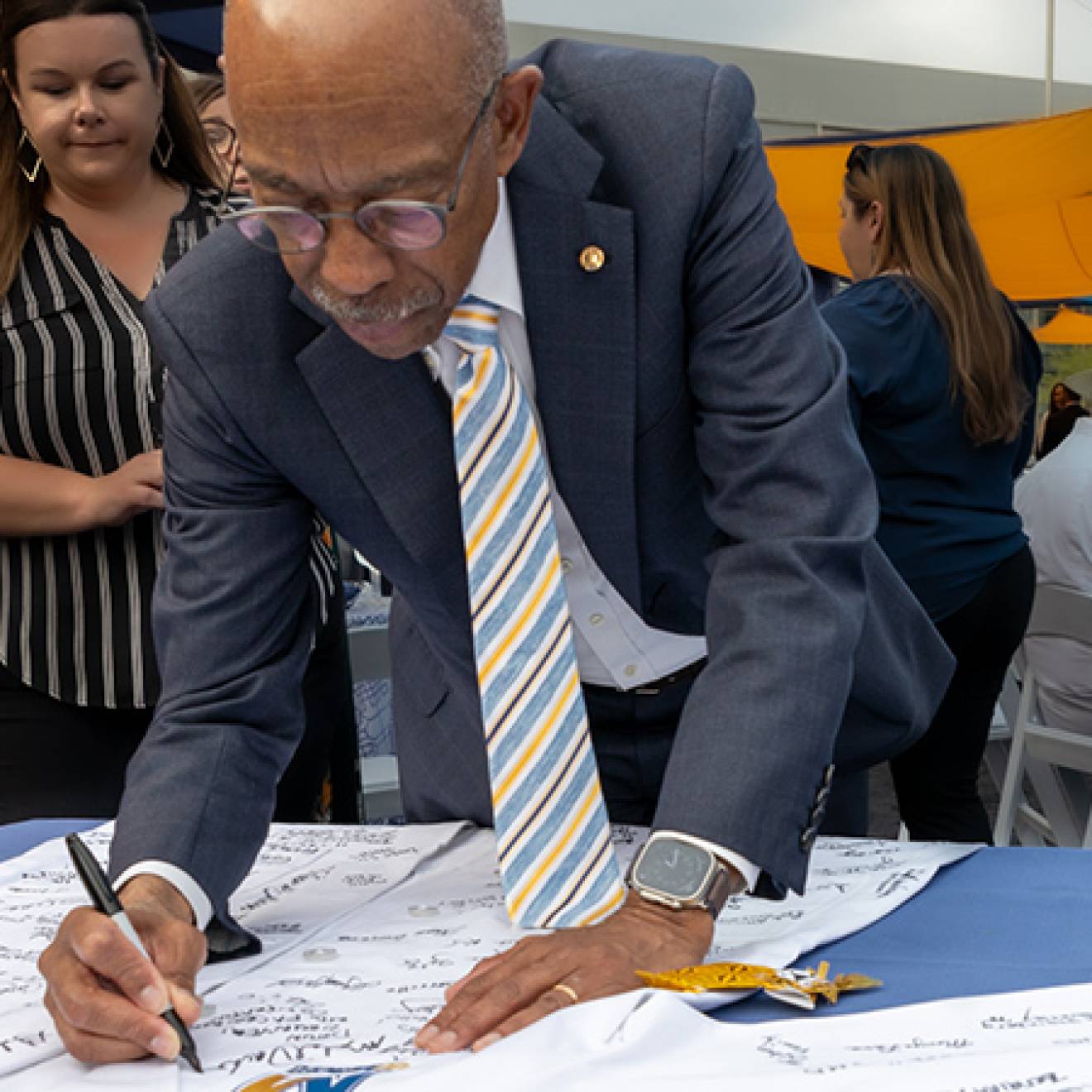 UC President Michael V. Drake M.D. signs a white coat