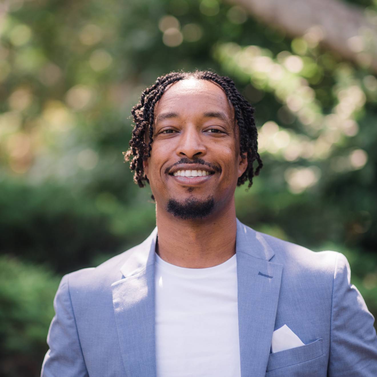 Smiling young Black man in a powder blue blazer, Merhawi Tesfai