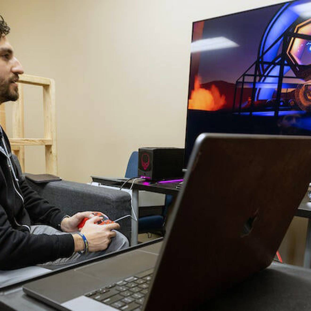 A young man with a beard playing a video game