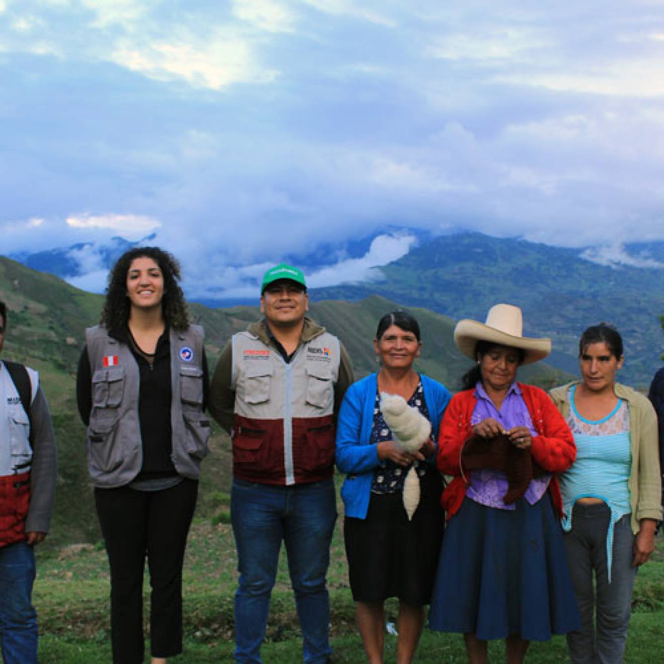 Neeka Mahdavi, a young Iranian-American woman, stands with her hosts in Peru with foggy, cloudy mountains in the background