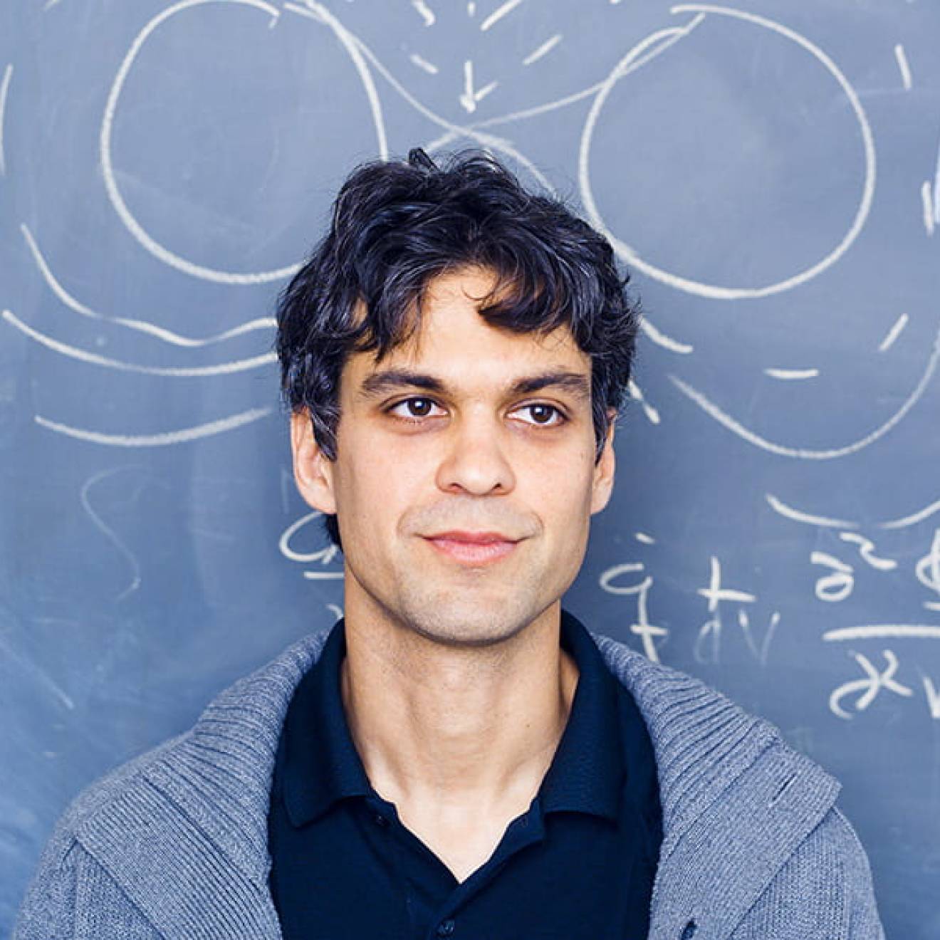 Enrico Ramirez-Ruiz in front of chalkboard