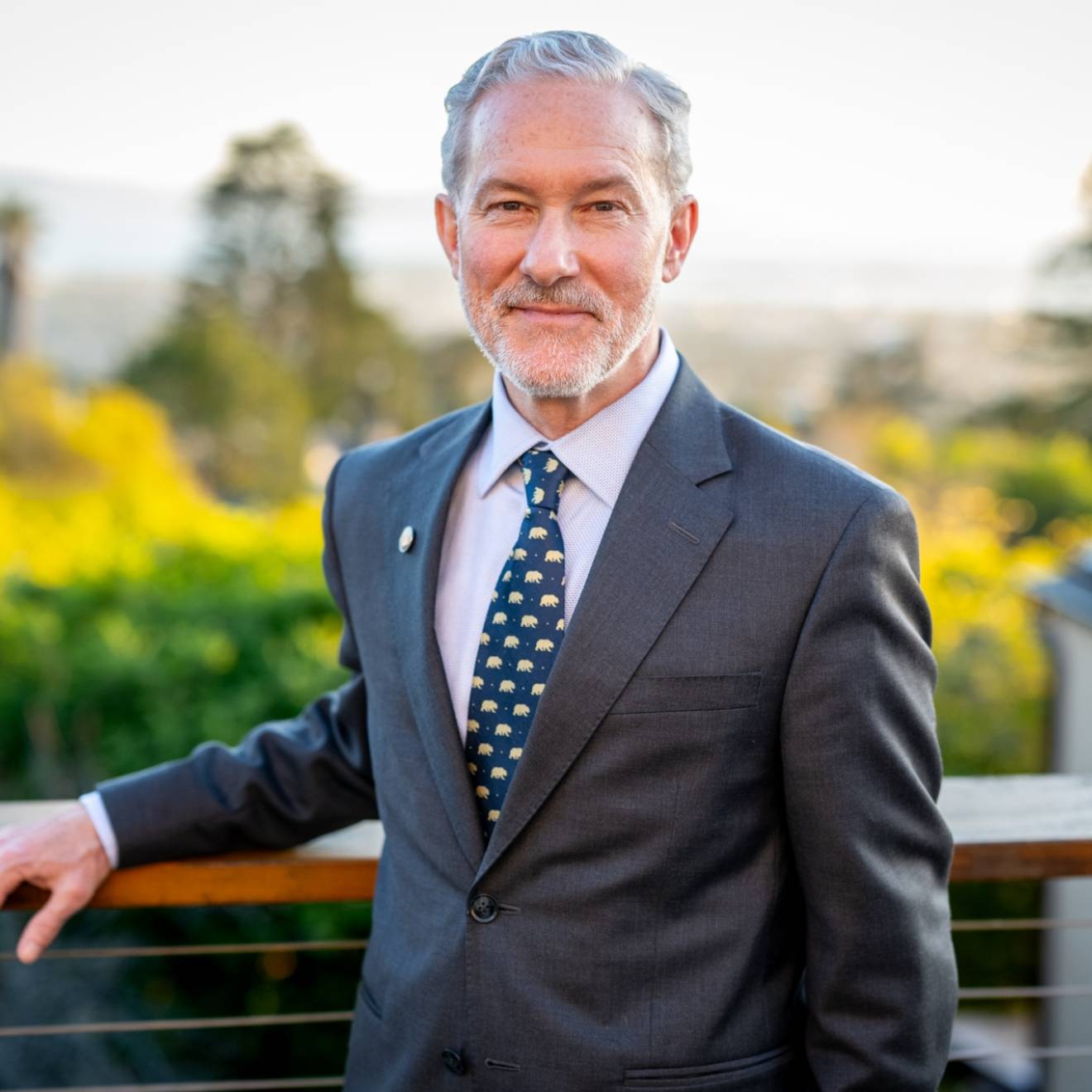 Rich Lyons, a white man with white hair and a white beard, smiling in a suit with a Berkeley bears tie, on campus