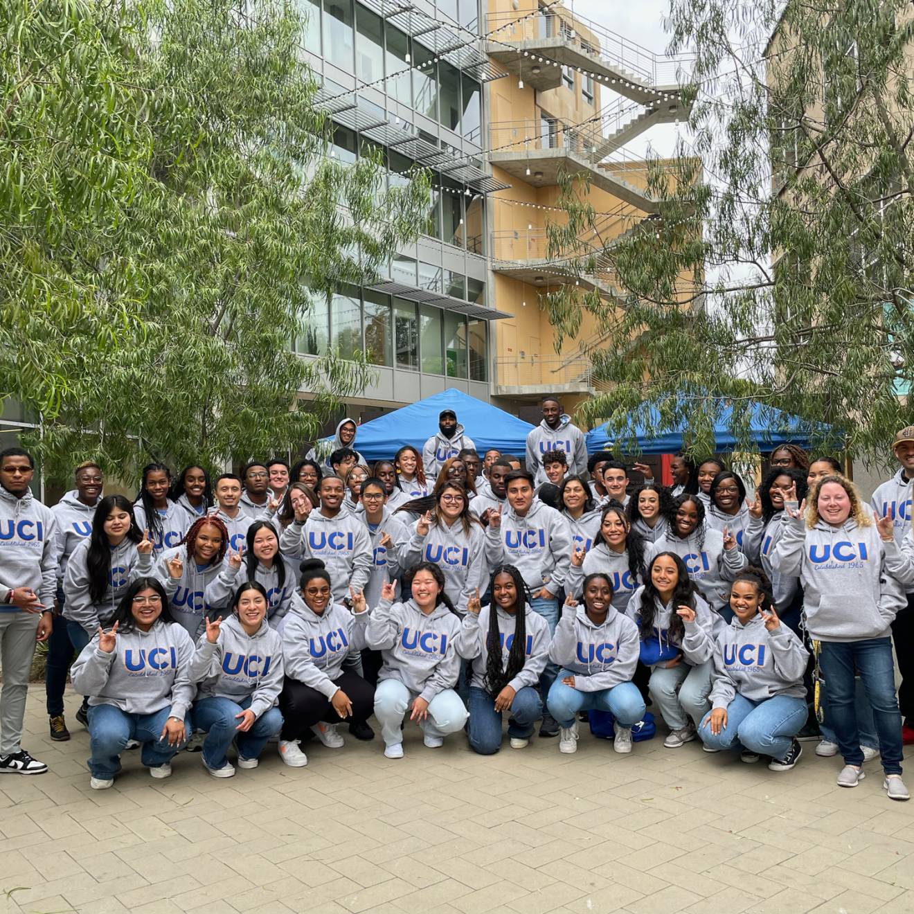 A group photo of SIEML 2023 on the UC Irvine campus, with everyone in UCI sweatshirts