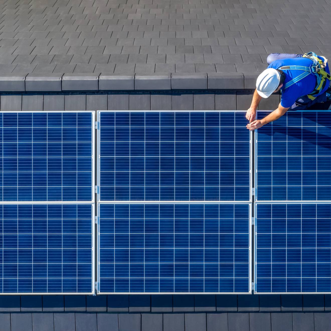 Man photographed from above working on a solar panel