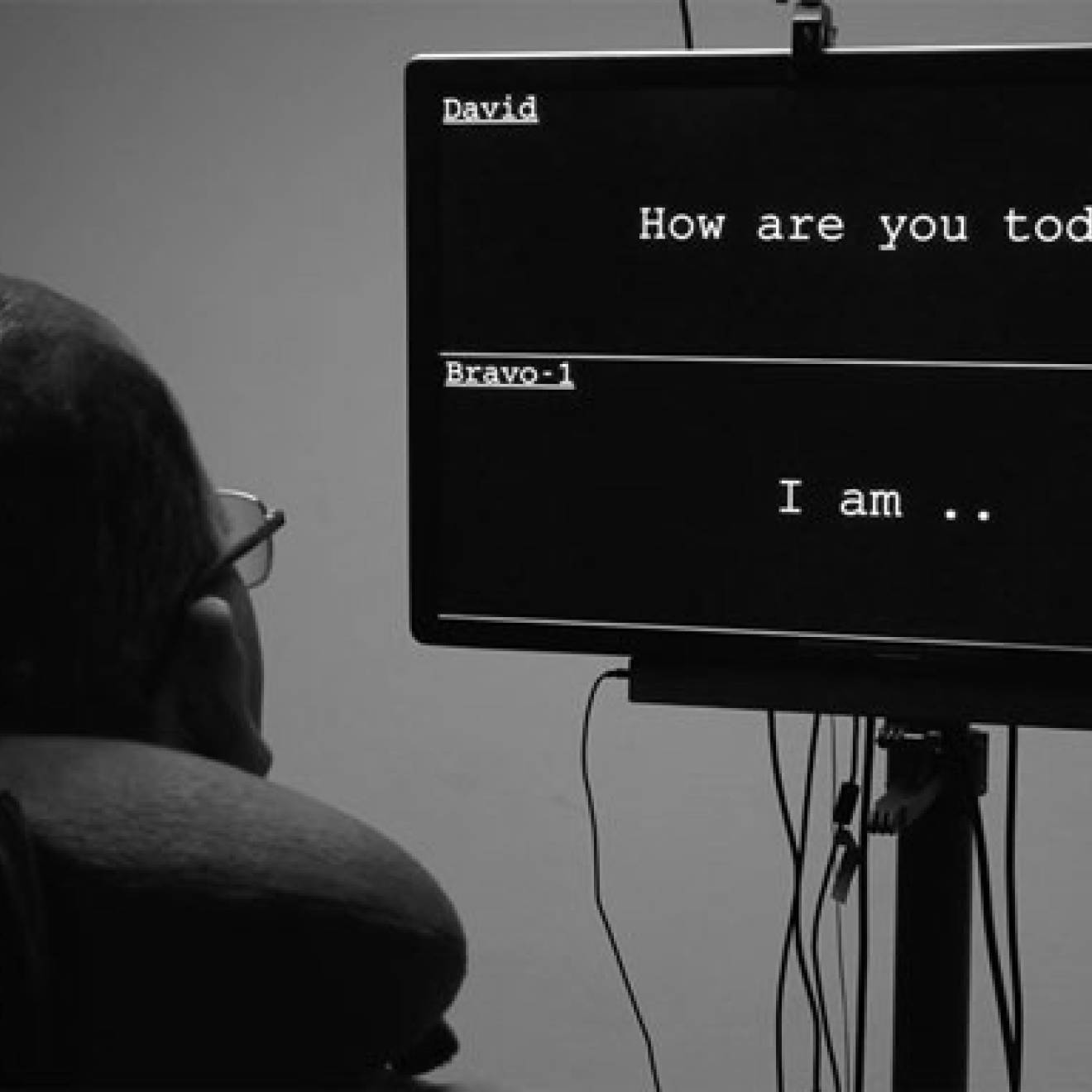A man looks at a screen where his words appear while wearing a device on his head