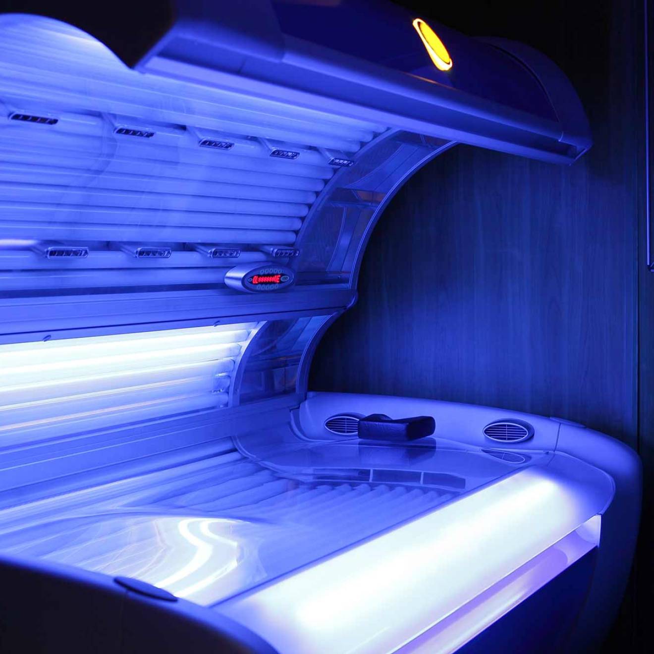 A tanning bed emitting a soft blue glow.