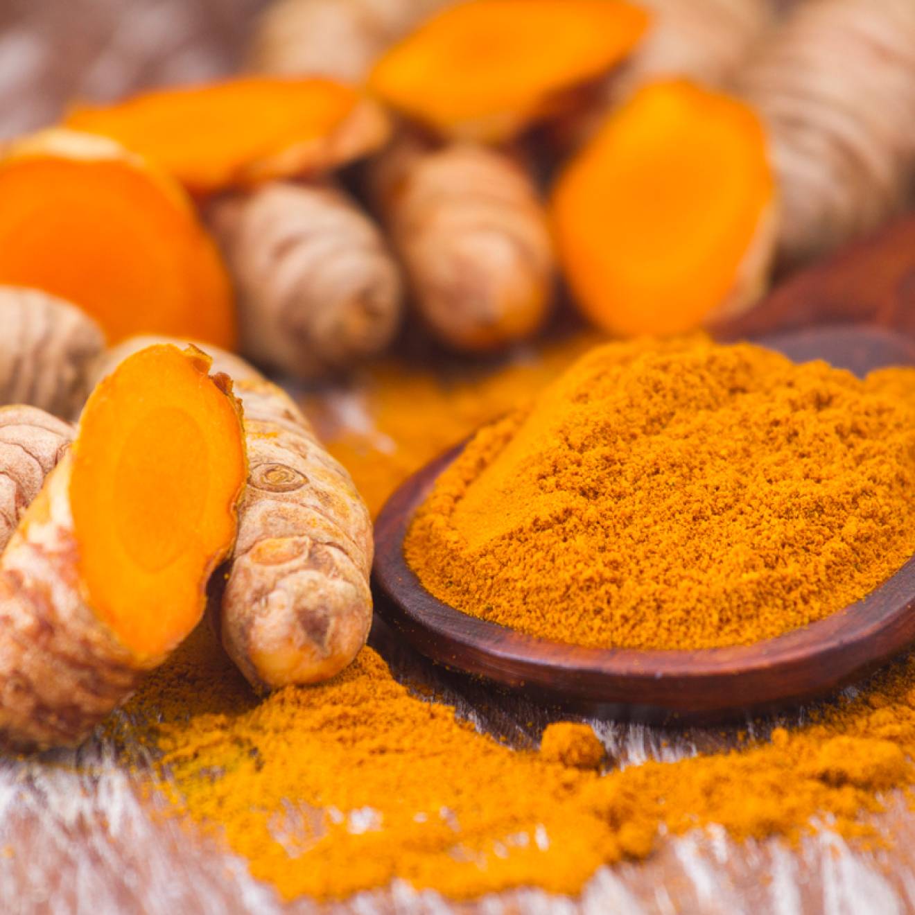Turmeric root next to turmeric powder