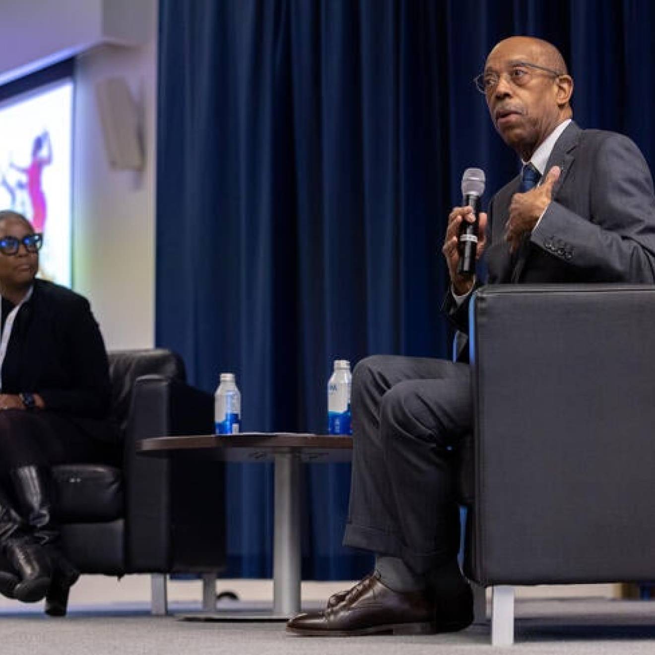 President Drake on stage with a Black woman educator as part of a panel