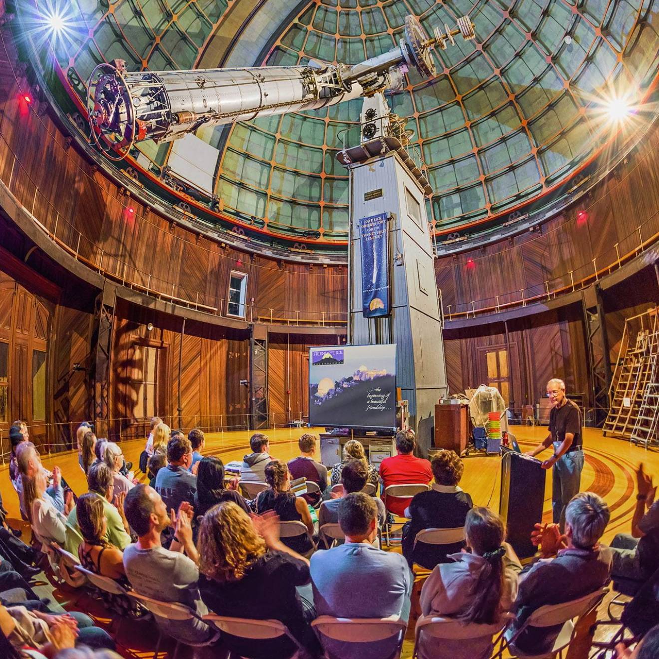 A presentation inside Lick Observatory, telescope visible, taken from a fish-angle lens