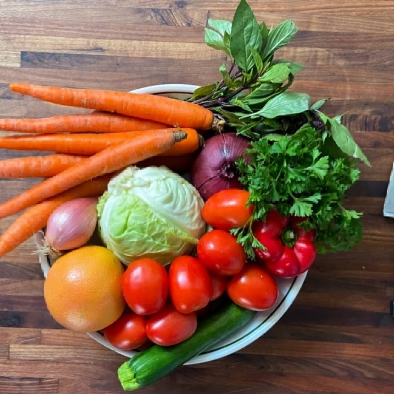 A plate of raw vegetables next to a knife