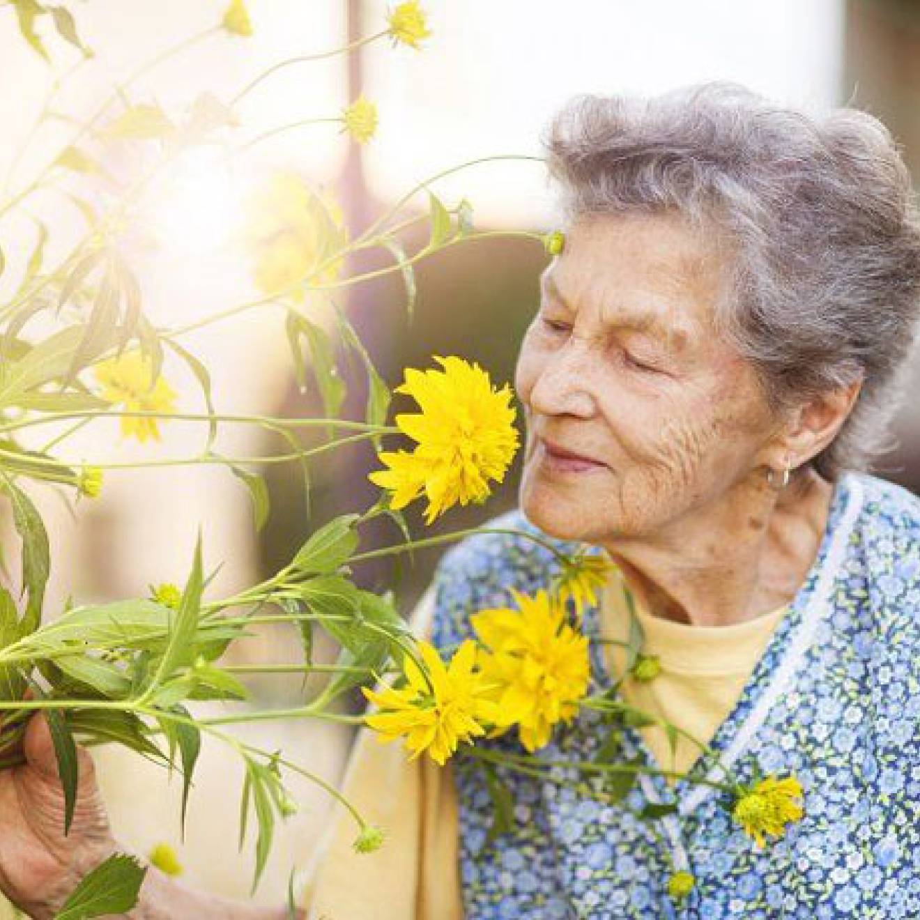 Older woman smelling flowers