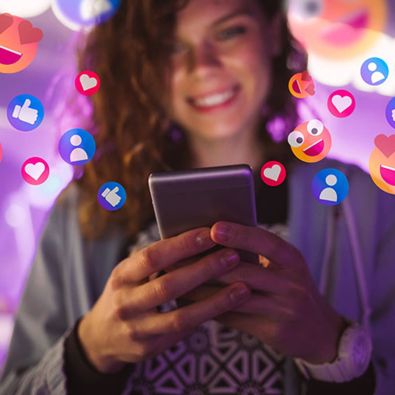 Happy young woman using her phone with emojis surrounding her