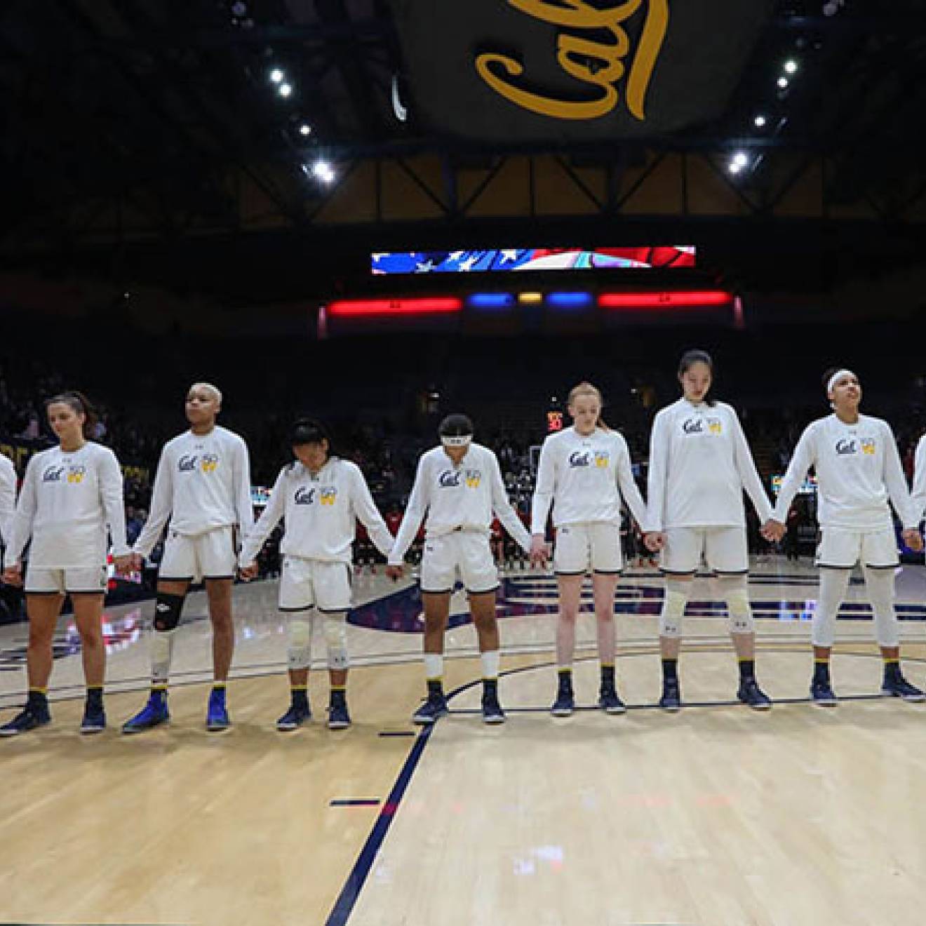 Women standing for anthem at basketball game