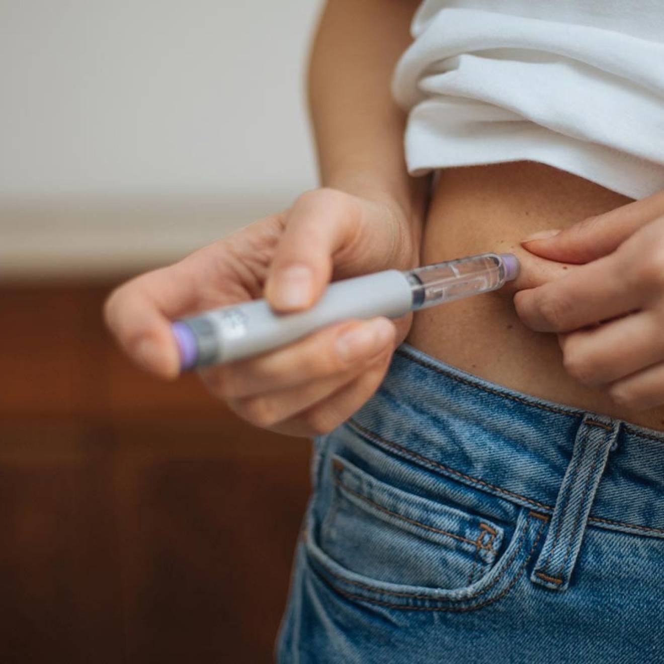 A white woman injecting her midsection