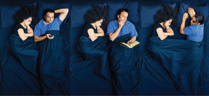 Man on cellphone, reading, tossing and turning next to continuously sleeping partner