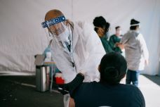 UC President Michael V. Drake, M.D., administering COVID-19 vaccinations to a person at a community pop-up immunization hub in San Francisco’s Mission District.