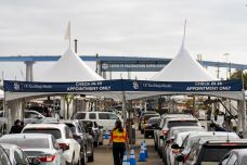 Cars in line for COVID-19 vaccination appointments at the check-in area at Petco Park in San Diego.