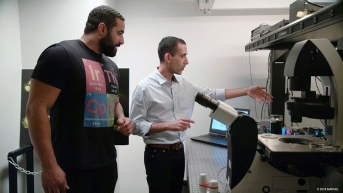 Two men look at a microscope