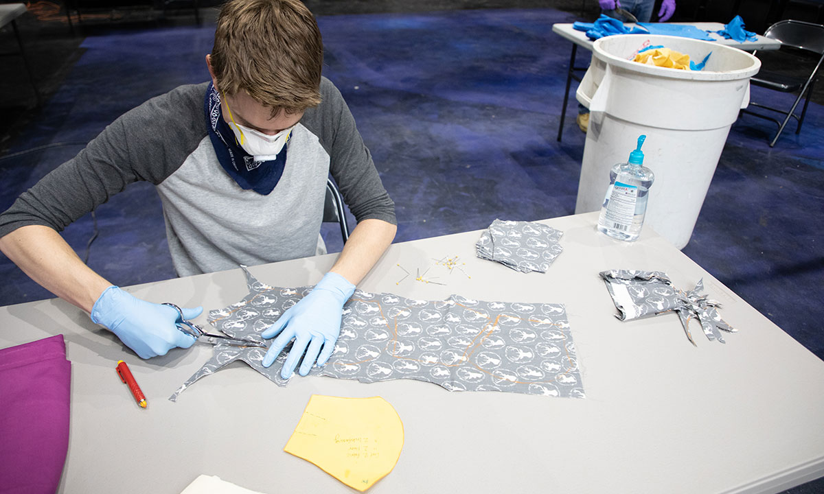 Man works at sewing face masks