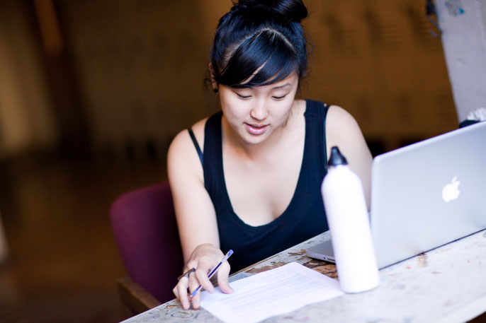 Young woman studies at computer