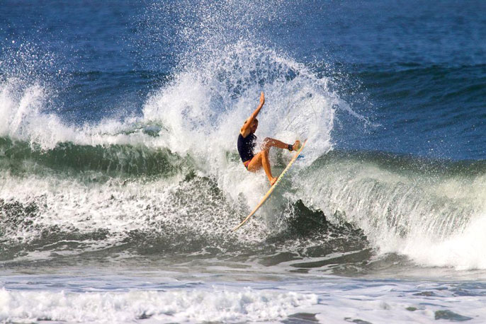 Woman surfing big wave