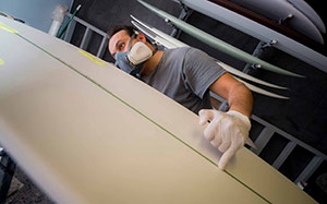worker prepares algae surfboard