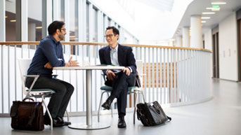 Two doctors talking in a UCSF hall at a table