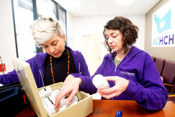 two doctors put medicine bottles into a box