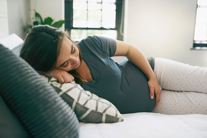 A pregnant woman relaxed on a bed