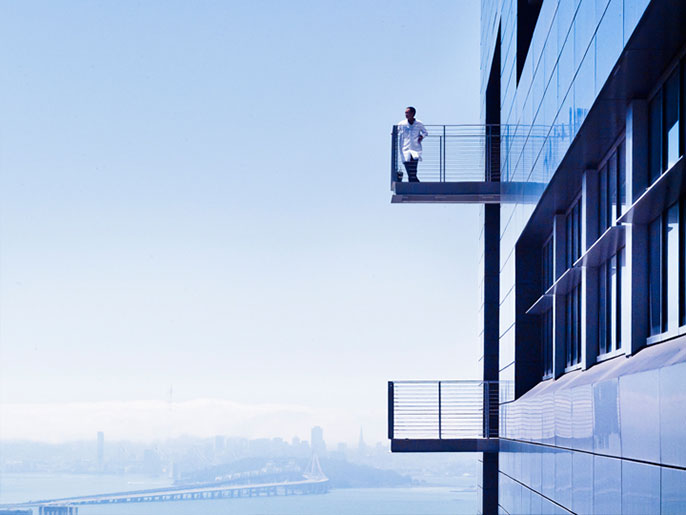 Researcher on a balcony with San Francisco skyline behind